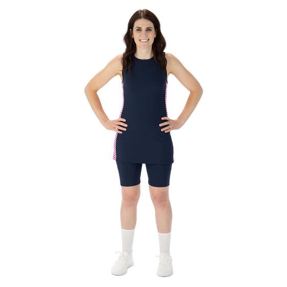 Midnight blue racerback tunic with pink and white striped side panels, blue pickleball shorts with nine inch inseam